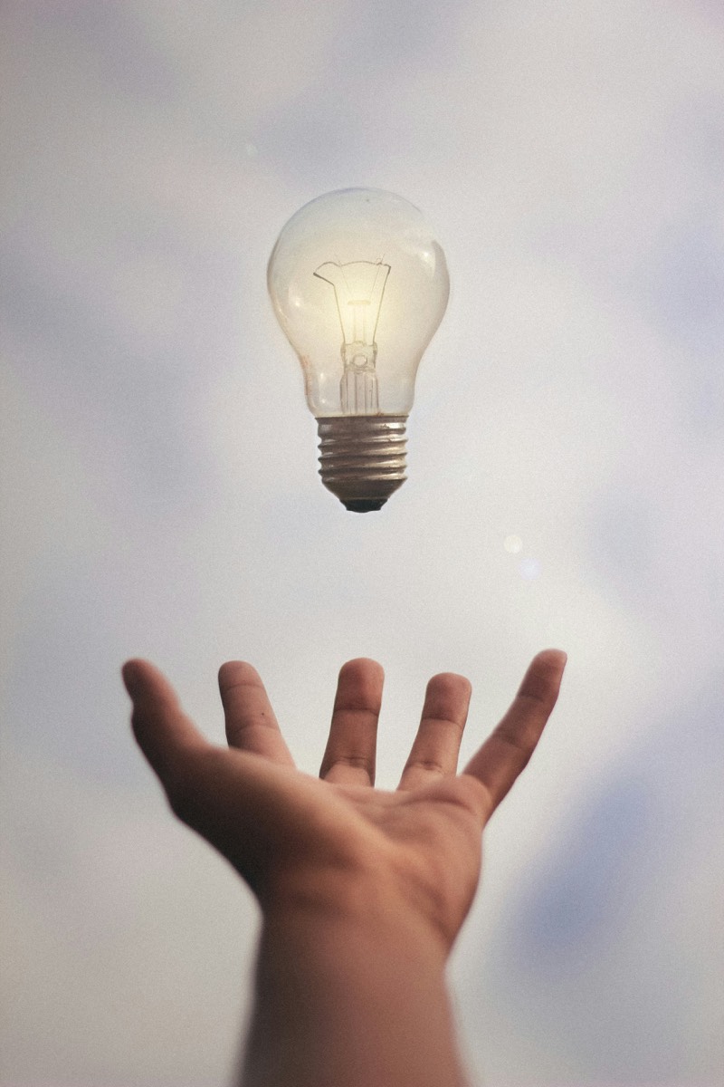 Idea e innovazione — mano che raggiunge una lampadina